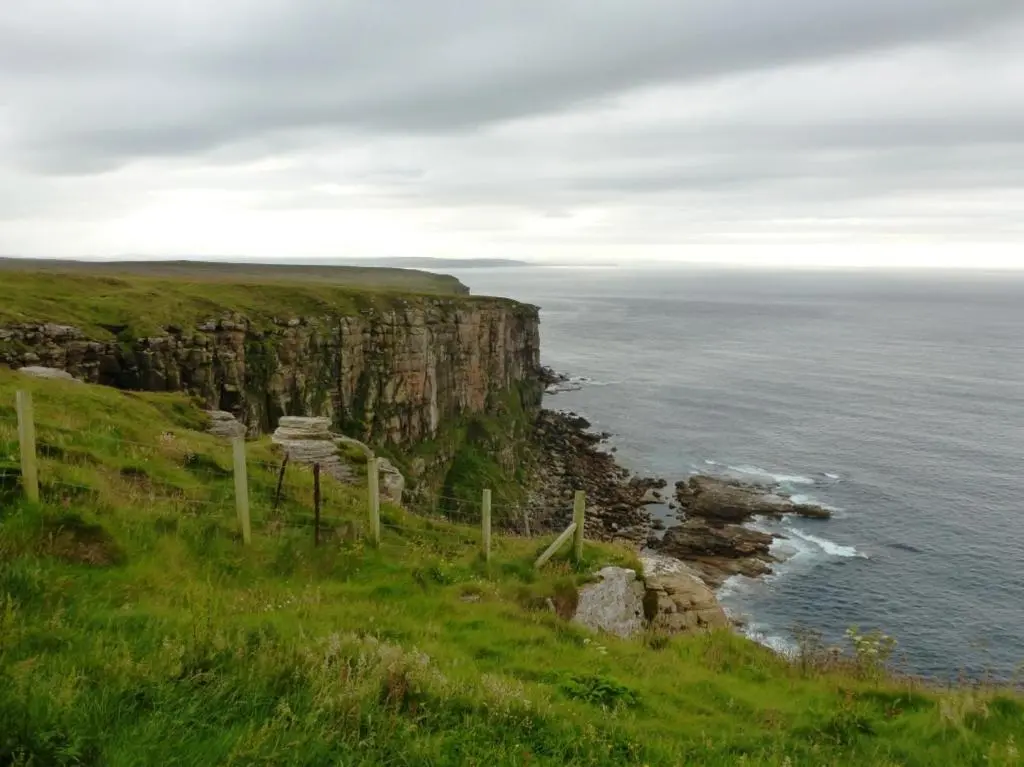 a cliff overlooking the ocean on a cloudy day at Norseman Hotel in Wick
