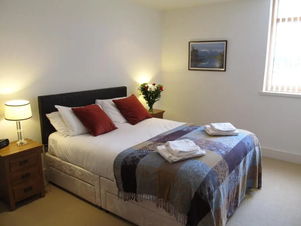 a bedroom with a bed with two towels on it at Bridge Street Apartments in Inverness
