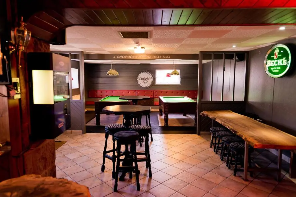 a bar with tables and stools in a restaurant at Leys Hotel in Aberdeen