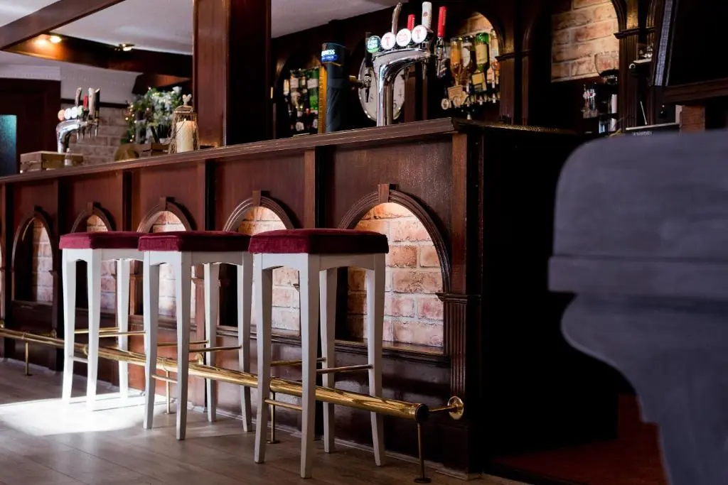 a row of bar stools in front of a bar at Leys Hotel in Aberdeen