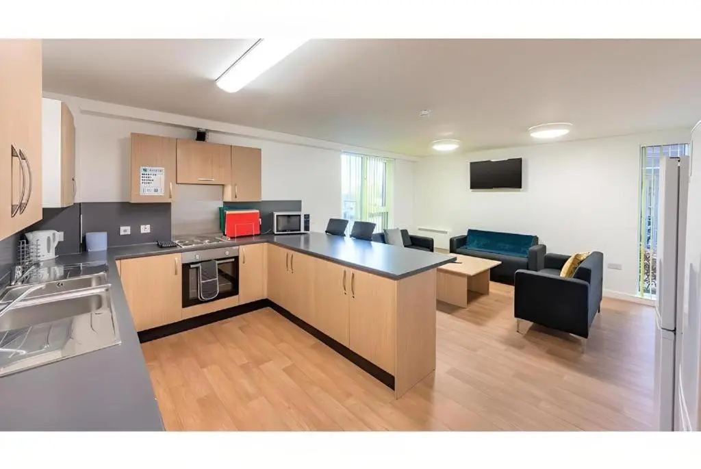 a kitchen and living room with a couch and a table at UHI Dornoch- Campus Accommodation in Dornoch