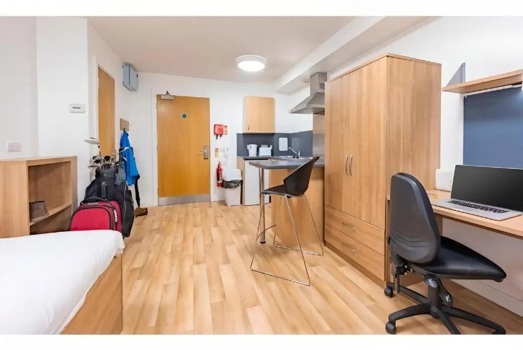 a room with a bed and a desk with a computer at UHI Dornoch- Campus Accommodation in Dornoch