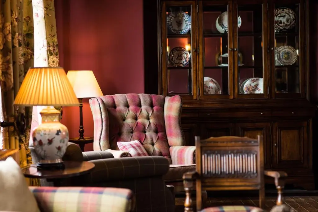 a living room with a chair and a lamp at Balmoral Arms in Ballater