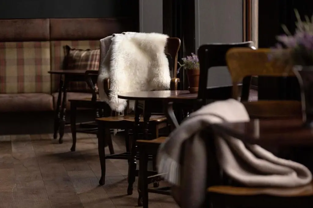 a living room with chairs and tables and a couch at Balmoral Arms in Ballater