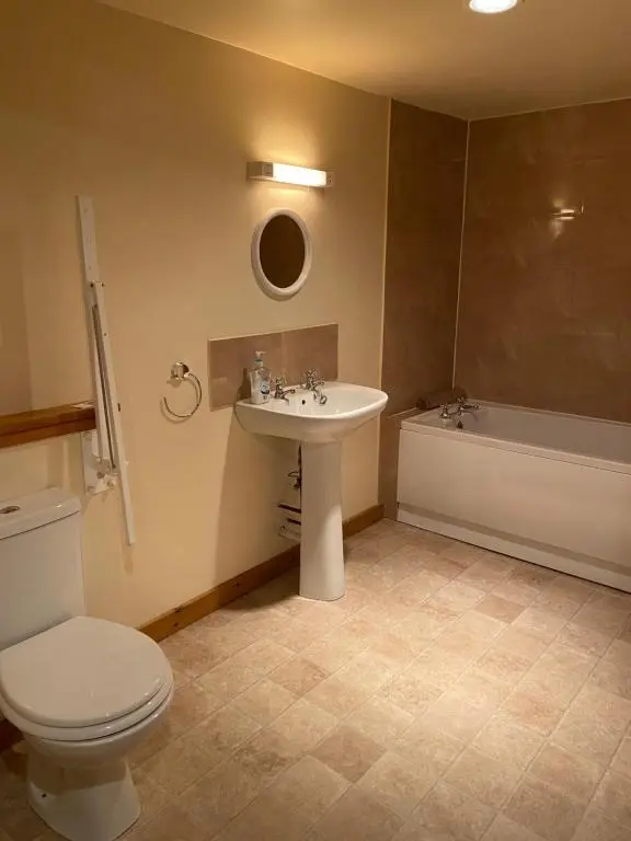 a bathroom with a sink and a toilet and a tub at Parkmore Holiday Cottages in Dufftown