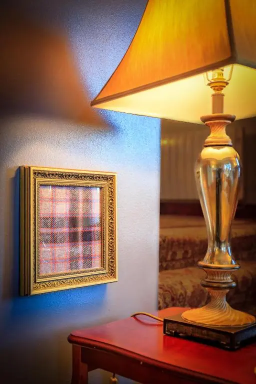 a lamp sitting on a table next to a mirror at Crubenbeg Country House in Newtonmore