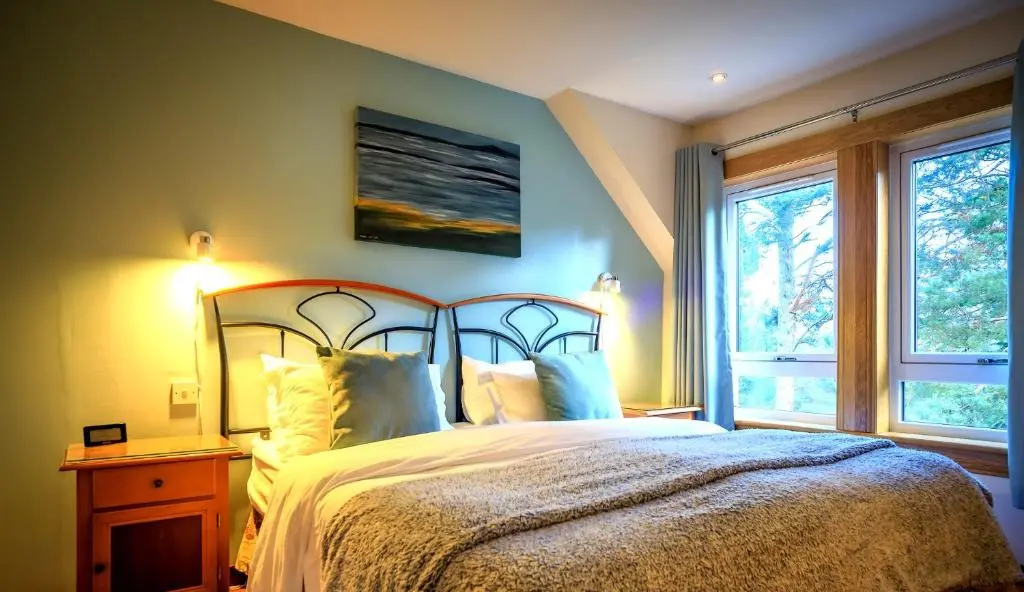 a bedroom with a large bed and a window at Crubenbeg Country House in Newtonmore