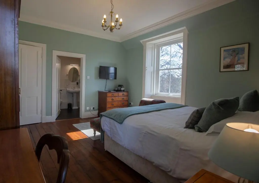 a bedroom with a bed and a window at Cardhu Country House in Aberlour