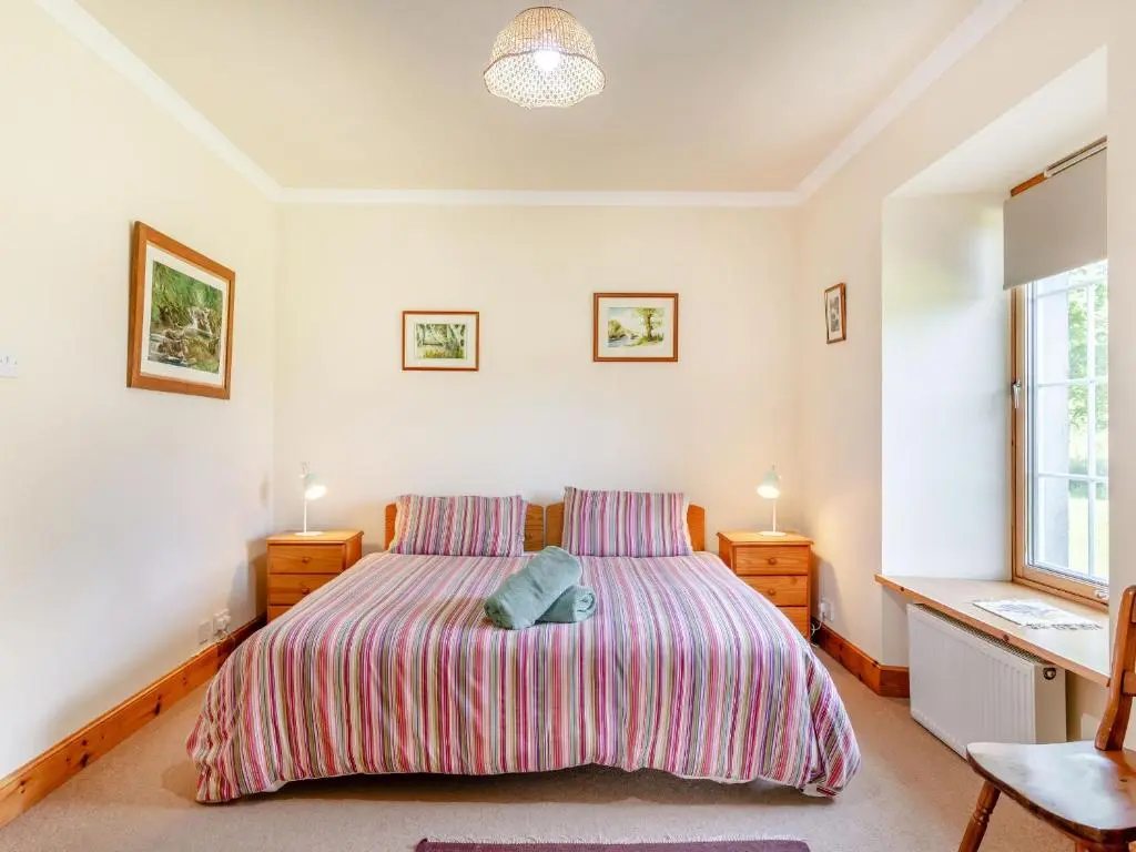 a bedroom with a bed and two night stands at The Old Laundry in Grantown on Spey