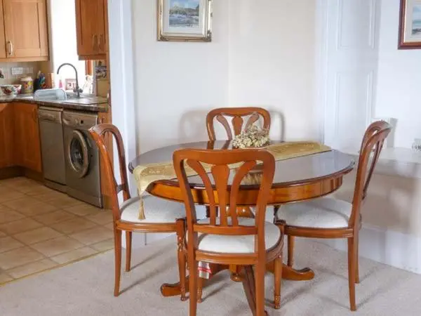 a kitchen with a table and four chairs at Seascape in Buckie