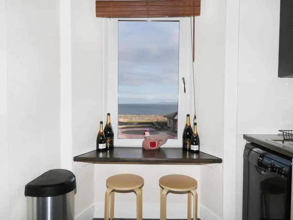 a small kitchen with a table with two stools at Seascape in Lossiemouth