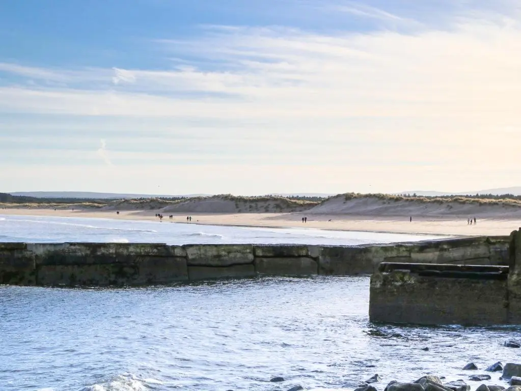 a body of water with a beach in the background at Seascape in Lossiemouth