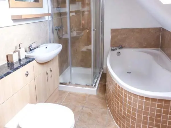 a bathroom with a shower and a sink and a toilet at Grace Cottage in Buckie