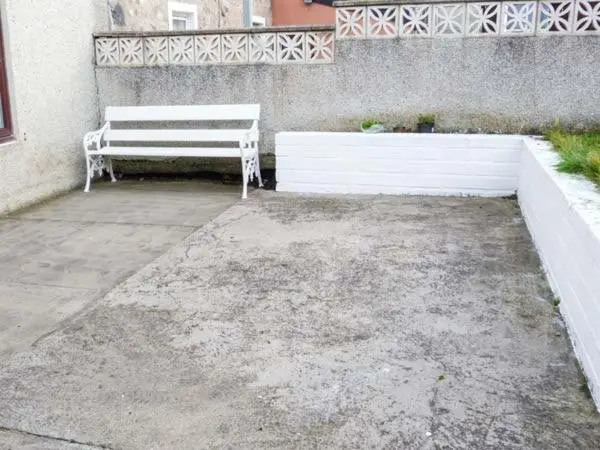 a white bench sitting in front of a building at Grace Cottage in Buckie