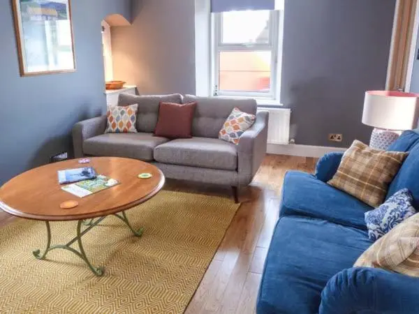 a living room with a couch and a table at Grace Cottage in Buckie