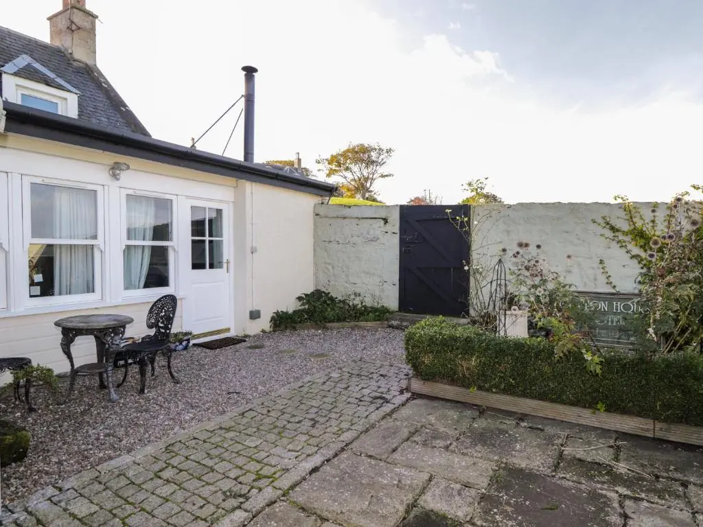 a patio with a table and chairs in front of a house at Seaview in Nairn