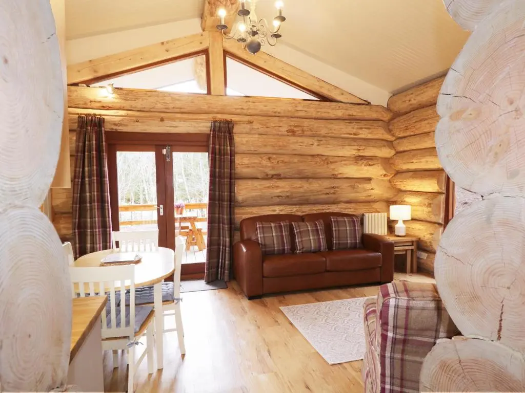 a living room with a couch and a table at Moorhen Lodge in Inverness