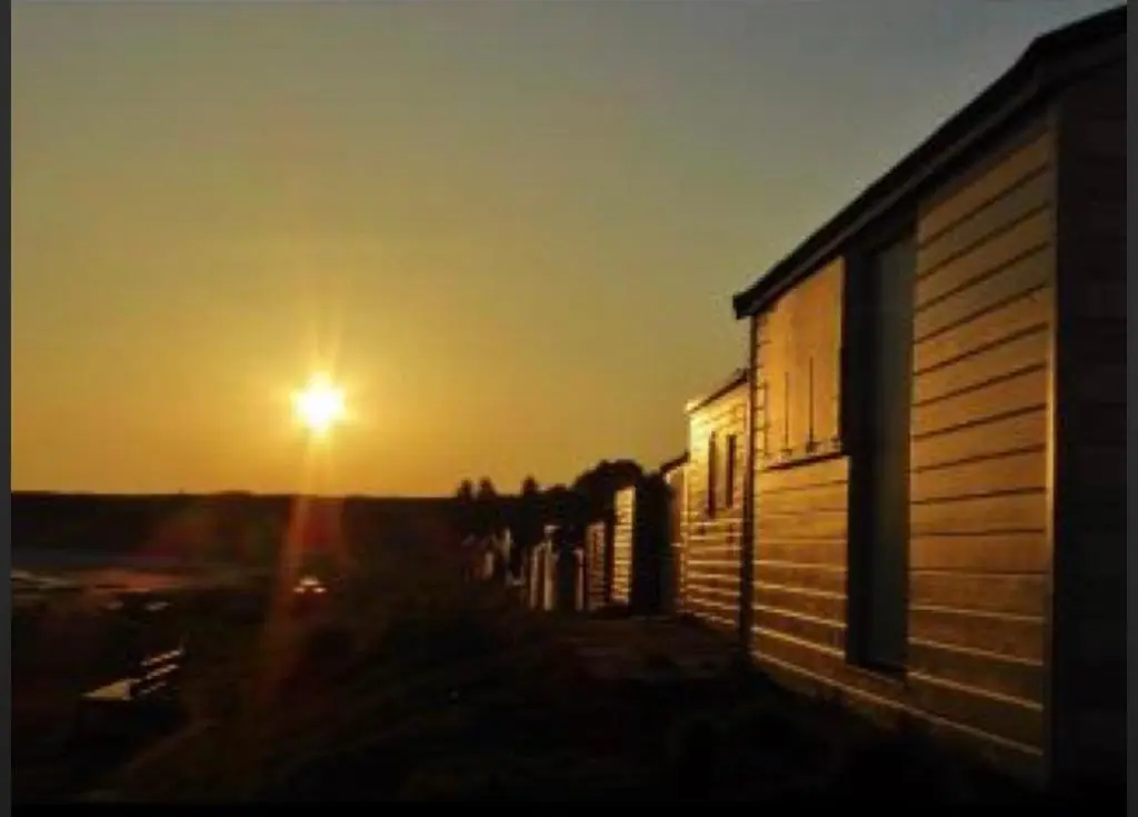 a building with the sunset in the background at BalMara in Hopeman