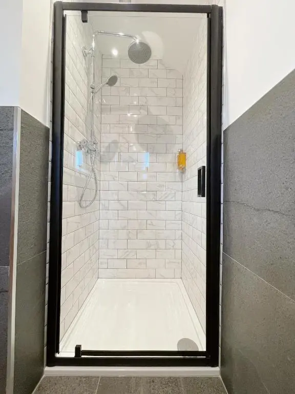 a shower with a glass door in a bathroom at Ravenscraig Guest House in Aviemore