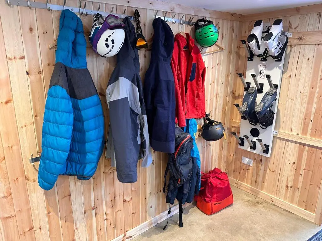 a wall with jackets and shoes hanging on it at Ravenscraig Guest House in Aviemore