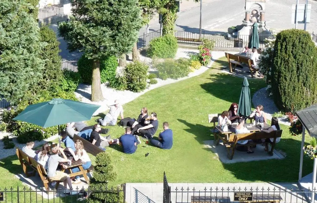 a group of people sitting in the grass at Haughton Arms Hotel in Alford