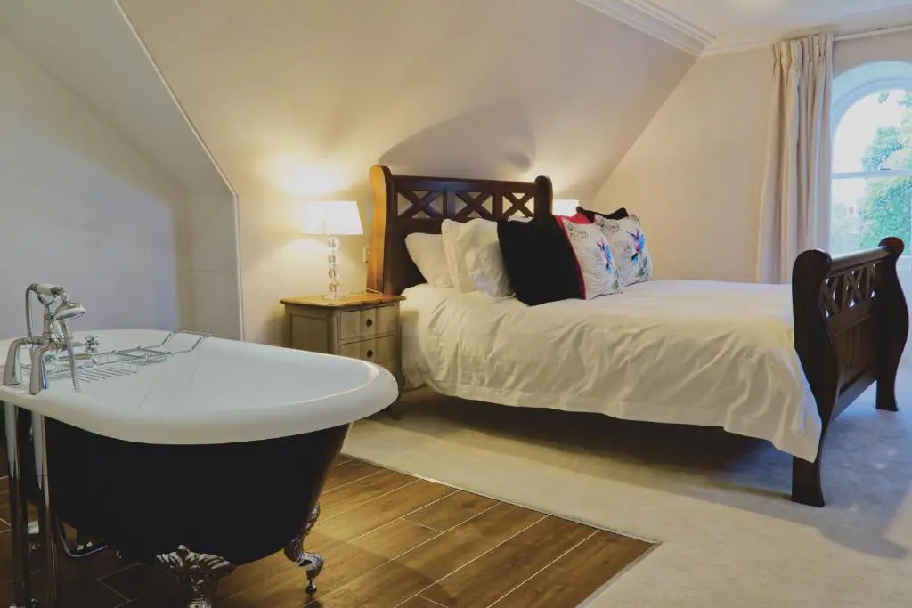 a bedroom with a bed and a bath tub at Mount Barker in Grantown on Spey