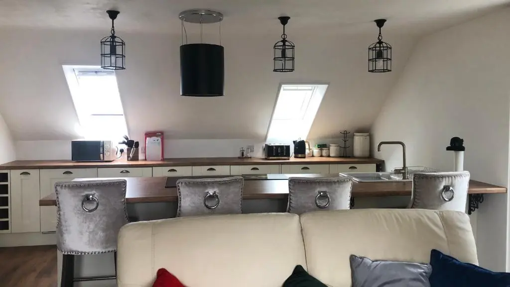a living room with a couch and a kitchen at Mount Barker in Grantown on Spey