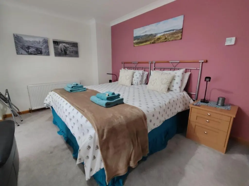a bedroom with a bed with a metal bed frame at Lann Dearg Studios in Invermoriston
