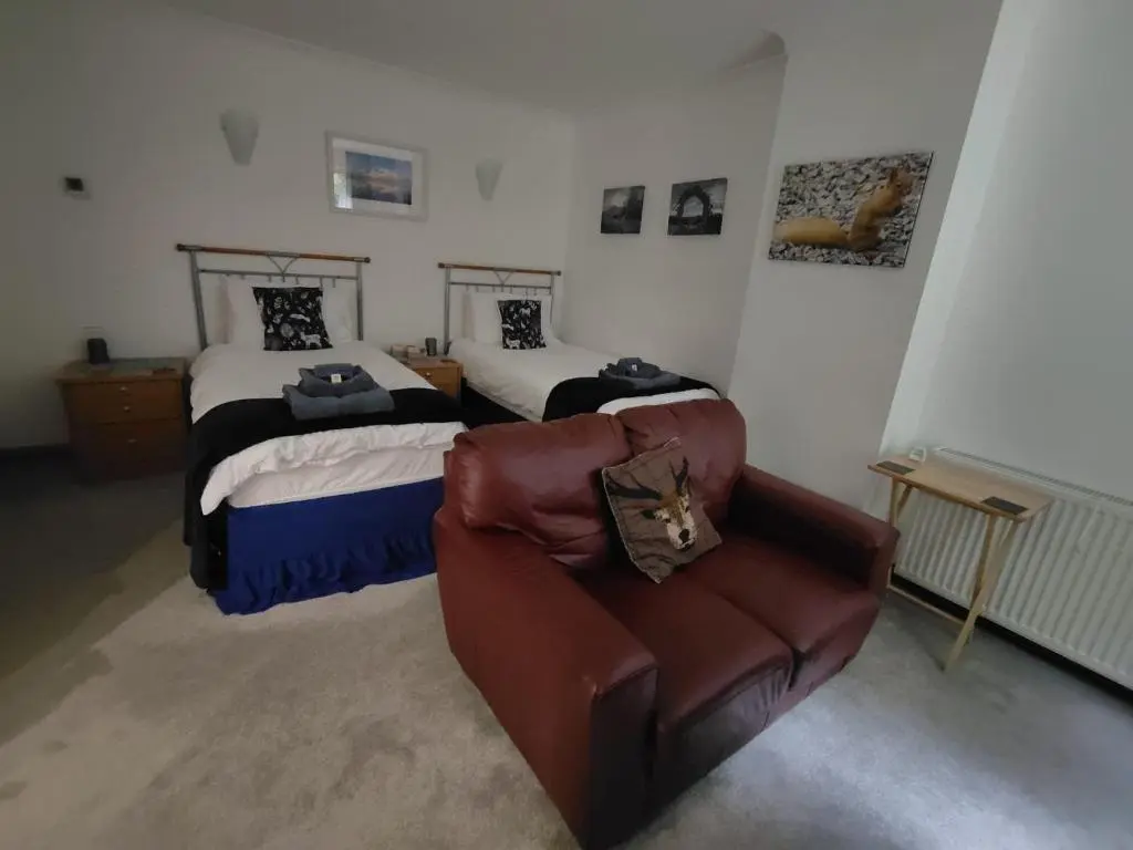 a living room with two beds and a couch at Lann Dearg Studios in Invermoriston