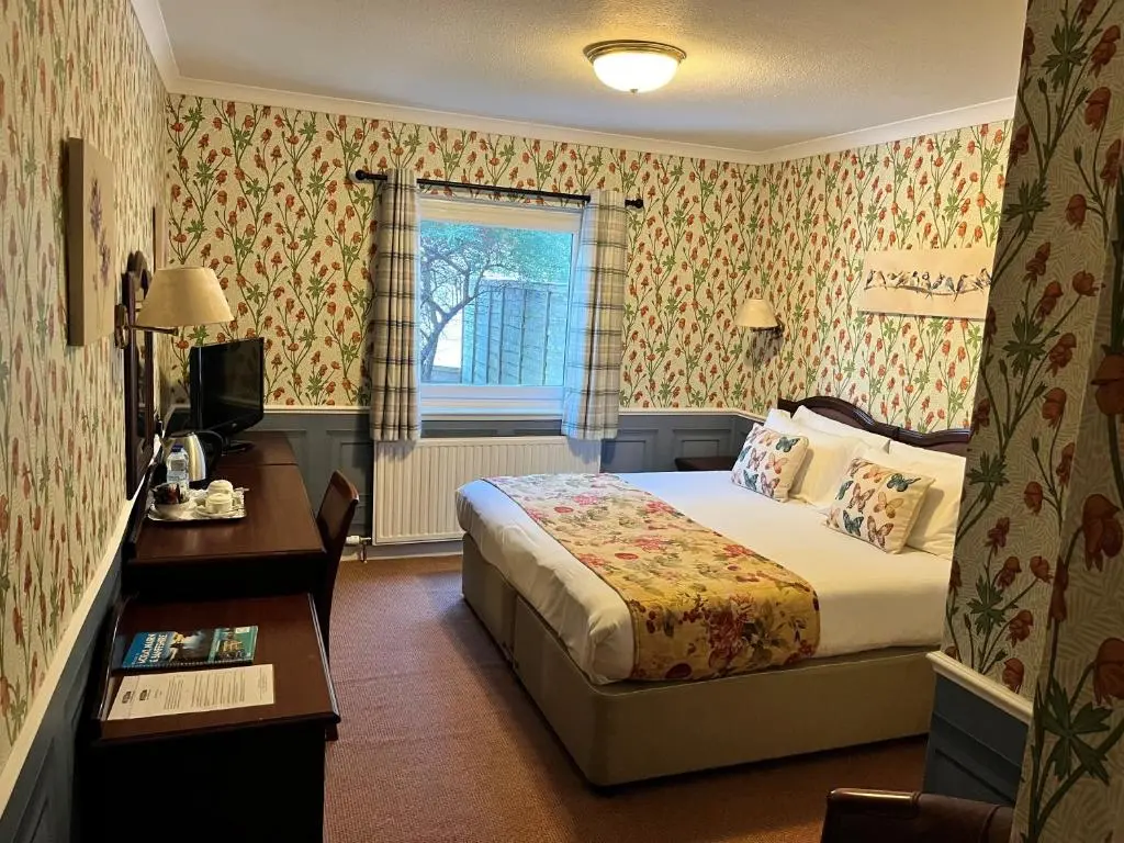a hotel room with a bed and a window at Ramnee Hotel in Forres