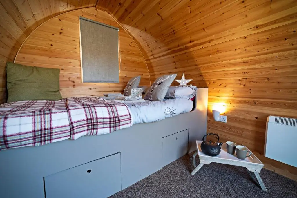 a bedroom with a bed in a wooden cabin at Howe of Torbeg in Ballater