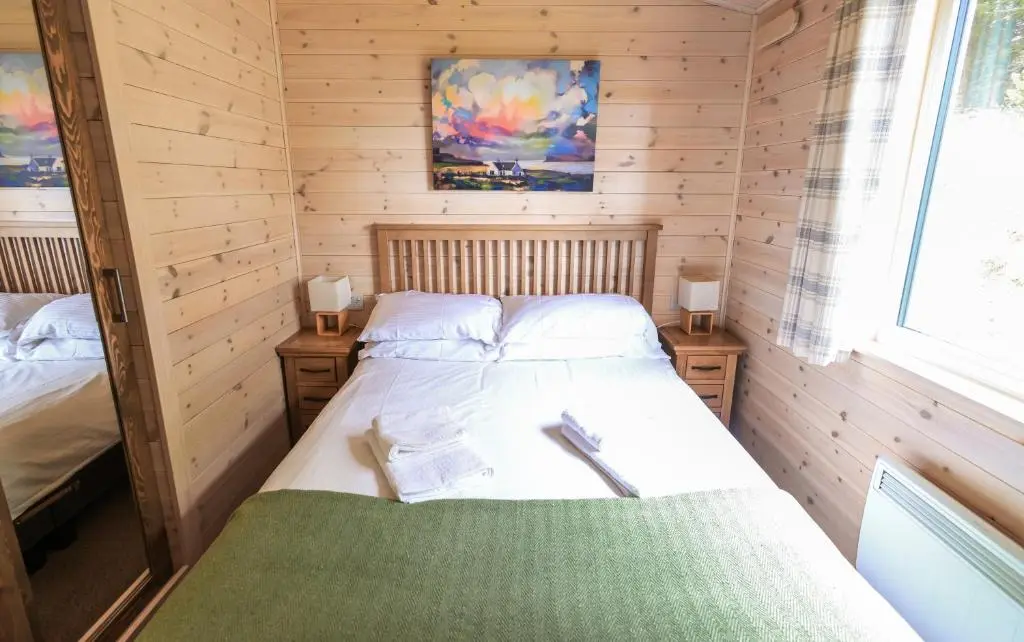 a bedroom with two beds in a wooden cabin at Burgie Woodland Lodges in Forres
