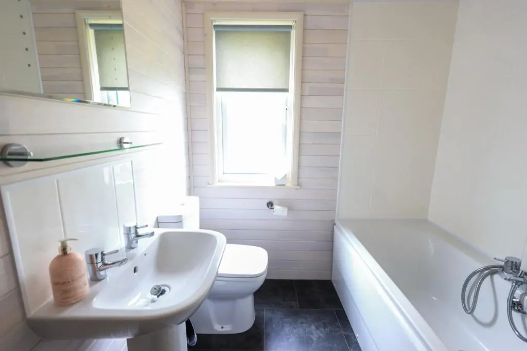 a bathroom with a sink and a toilet and a tub at Burgie Woodland Lodges in Forres