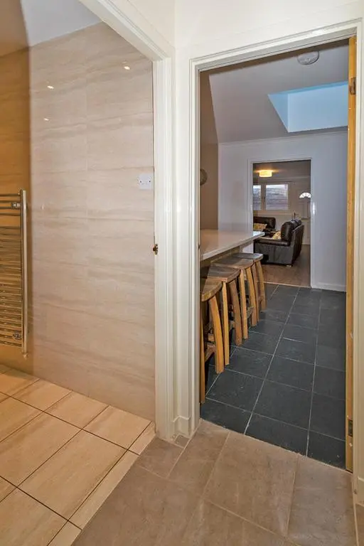 a room with a kitchen with a counter and some chairs at 37A Commerce Street in Lossiemouth