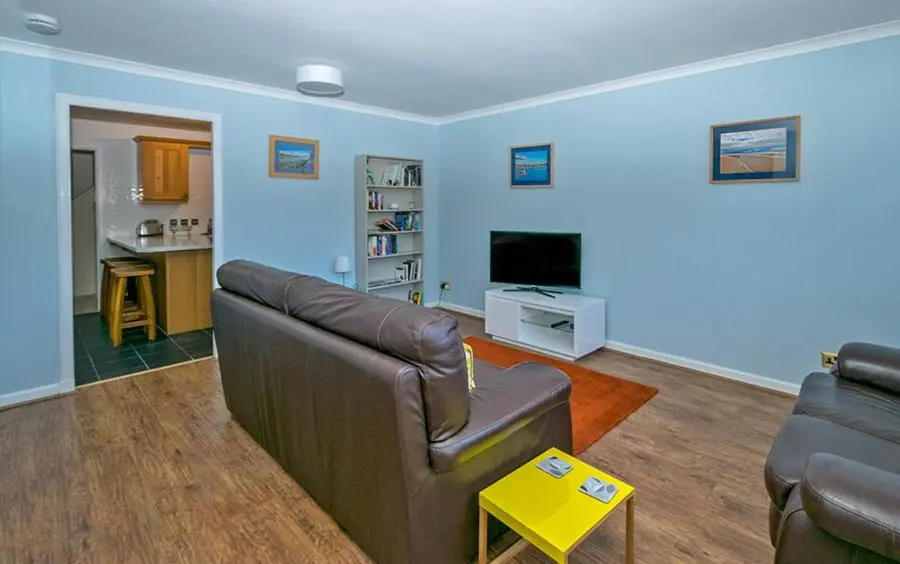 a living room with a couch and a television at 37A Commerce Street in Lossiemouth