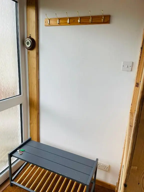 a blue bench sitting in a room next to a window at The Stroops in Helmsdale