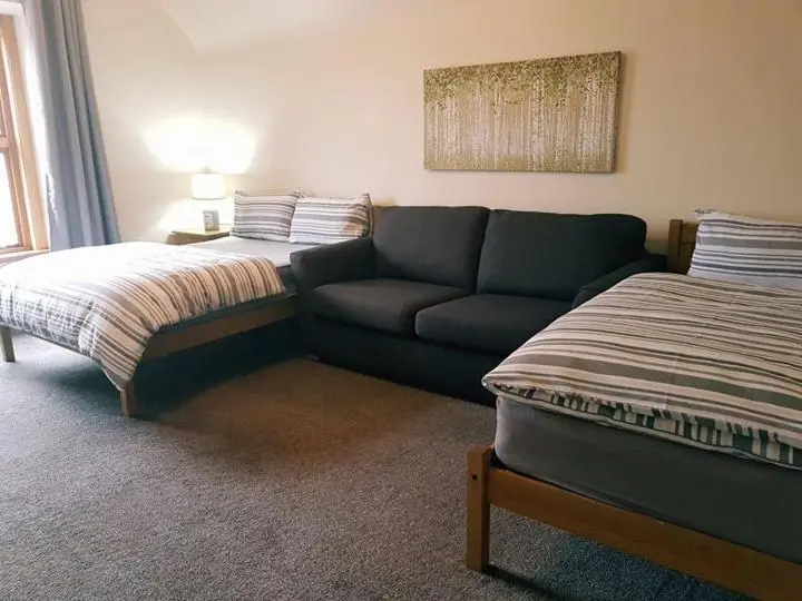 a living room with a couch and a bed at Yvi's 2-3 Bedroom Town Apartment in Inverurie