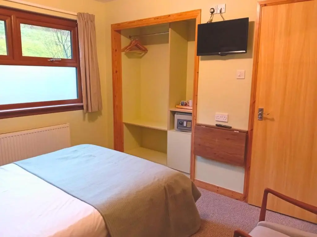 a bedroom with a bed and a television in it at Deveron Lodge B&B in Turriff