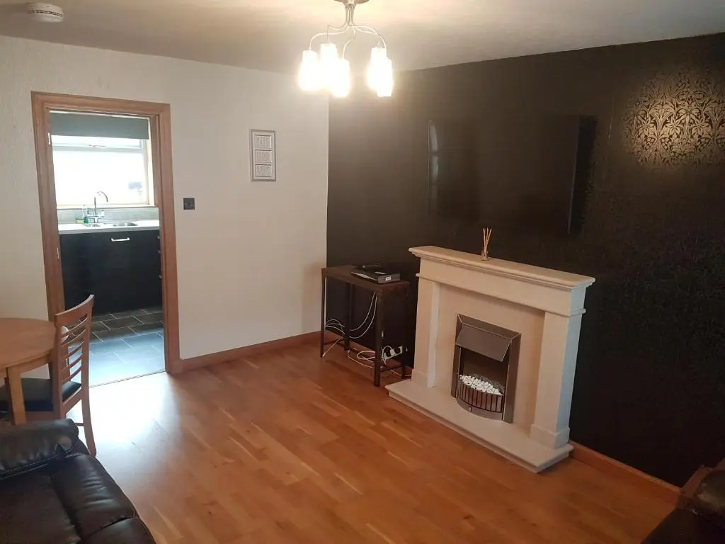 a living room with a fireplace and a television at Jane's Place Free Parking in Inverness