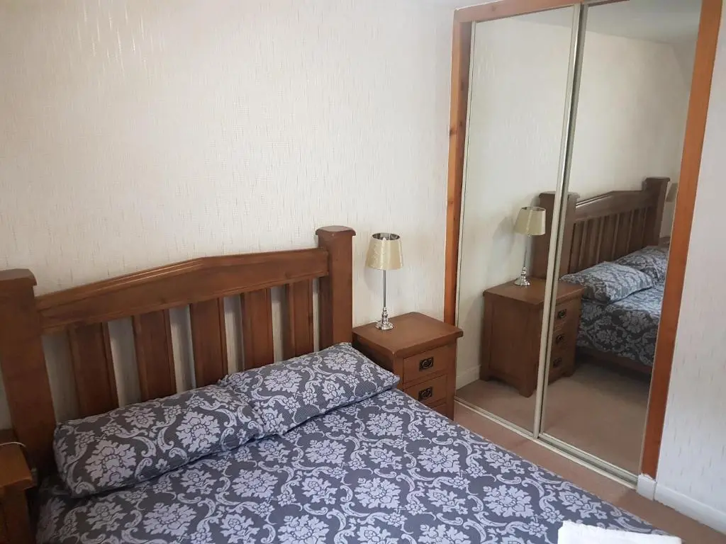 a bedroom with a bed and a mirror at Jane's Place Free Parking in Inverness