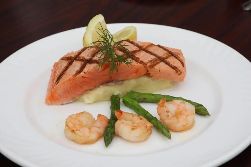 a white plate with shrimp and asparagus on a table at Sunninghill Hotel in Elgin