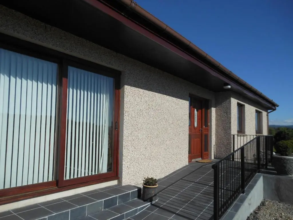 a house with a glass door and a balcony at Hillview Park in Beauly