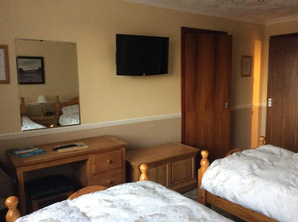 a bedroom with two beds and a mirror at Hillview Park in Beauly
