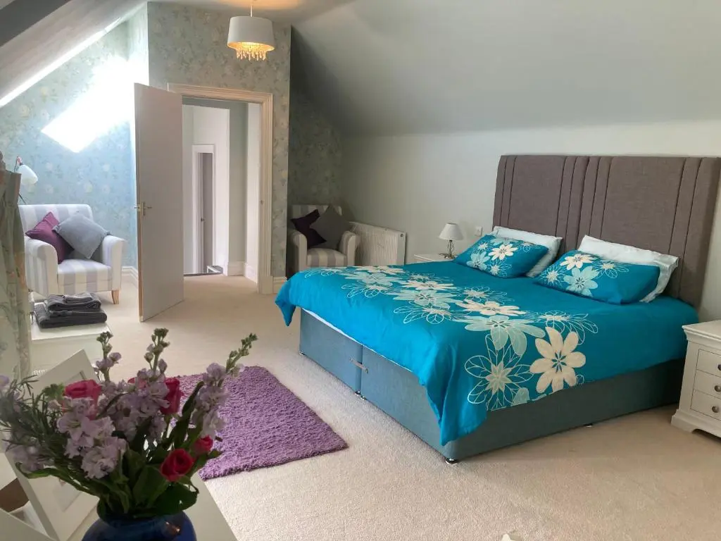 a bedroom with a blue bed with flowers on it at Woodside Steading in Huntly