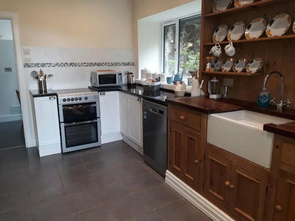 a kitchen with a stove and a sink at Woodside Steading in Huntly