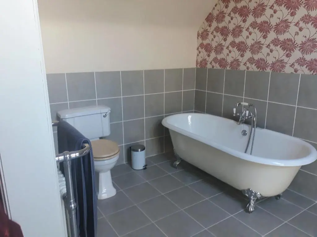 a bathroom with a white tub and a toilet at Woodside Steading in Huntly