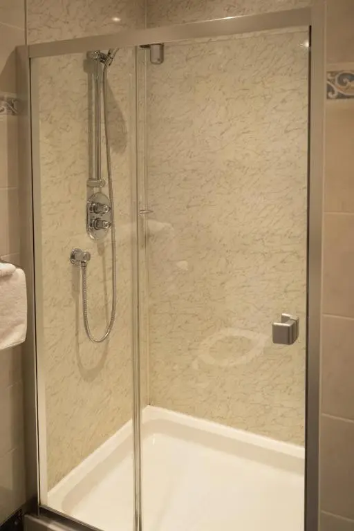 a shower with a glass door in a bathroom at Station Hotel in Ellon