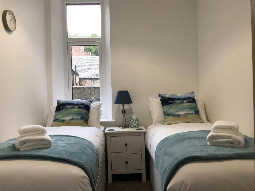 two twin beds in a small room with a window at Dryburgh Apartment No3 in Inverness