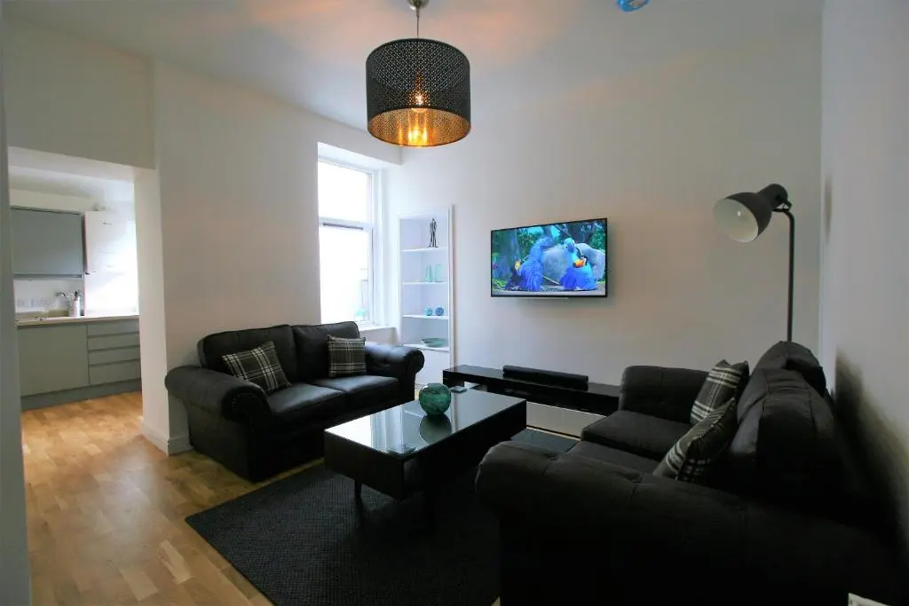 a living room with two couches and a table at Dryburgh Apartment No3 in Inverness