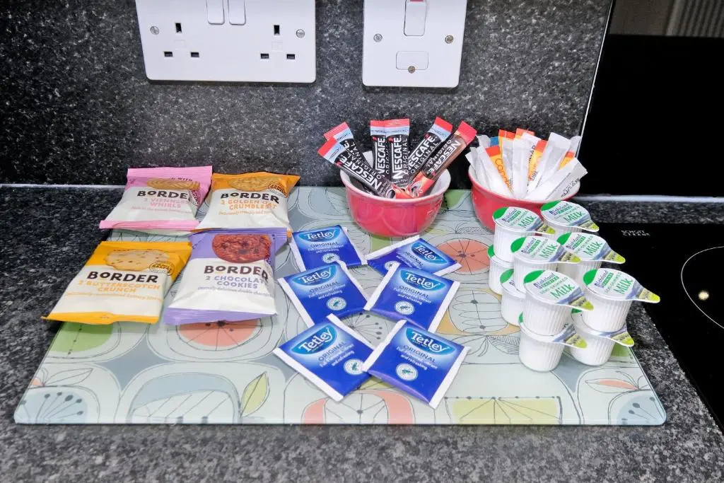 a table topped with packets of toothpaste and toothbrushes at Caledonia Netherhills Apartment in Aberdeen